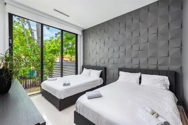 a bedroom with two beds and a large window