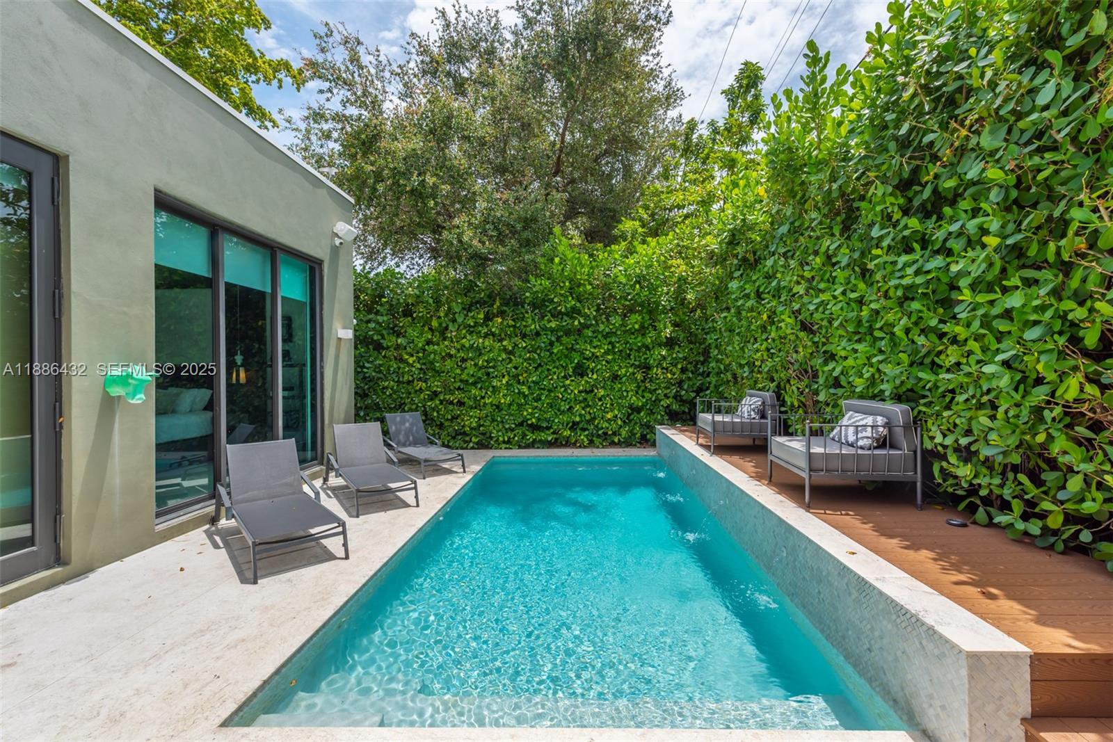 4675 Northeast 2nd Avenue Miami, FL 33137 - Photo 39 of 44 a backyard of a house with table and chairs