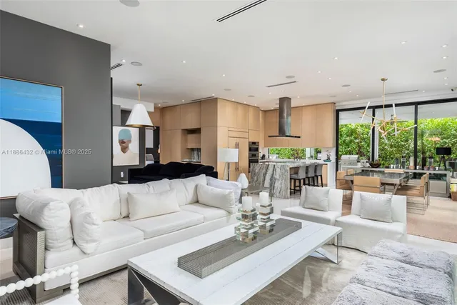 a living room with furniture kitchen view and large windows