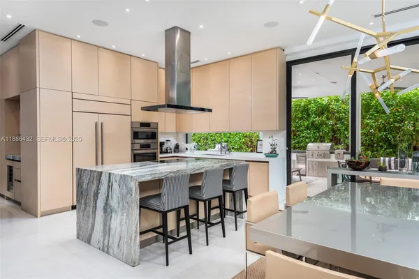 a kitchen with stainless steel appliances a table and chairs in it