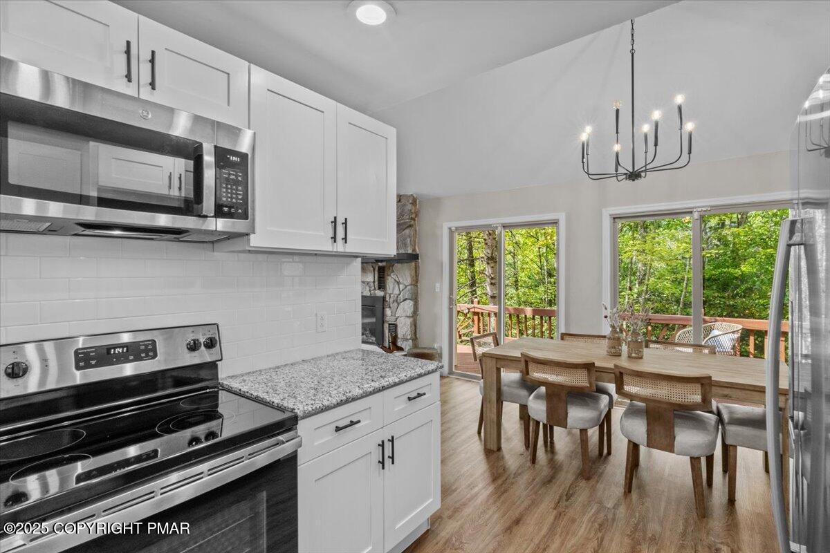 415 Canterbury Road Bushkill, PA 18324 - Photo 10 of 36 a kitchen with a stove a microwave and wooden floor
