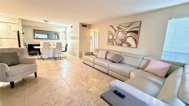a bedroom with a bed and a chandelier with a flat tv screen