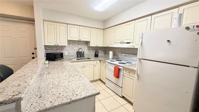 a kitchen with a stove sink and cabinets