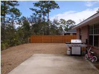 151 Buck Road Santa Rosa Beach, FL 32459 - Photo 2 of 16 a backyard of a house with barbeque oven and outdoor seating