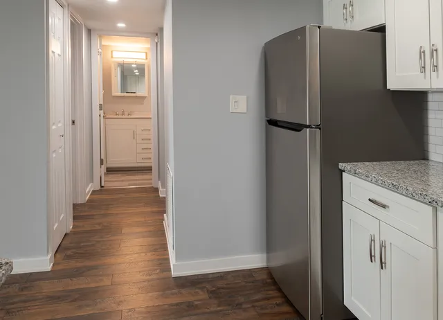 a kitchen with granite countertop white cabinets sink and stainless steel appliances