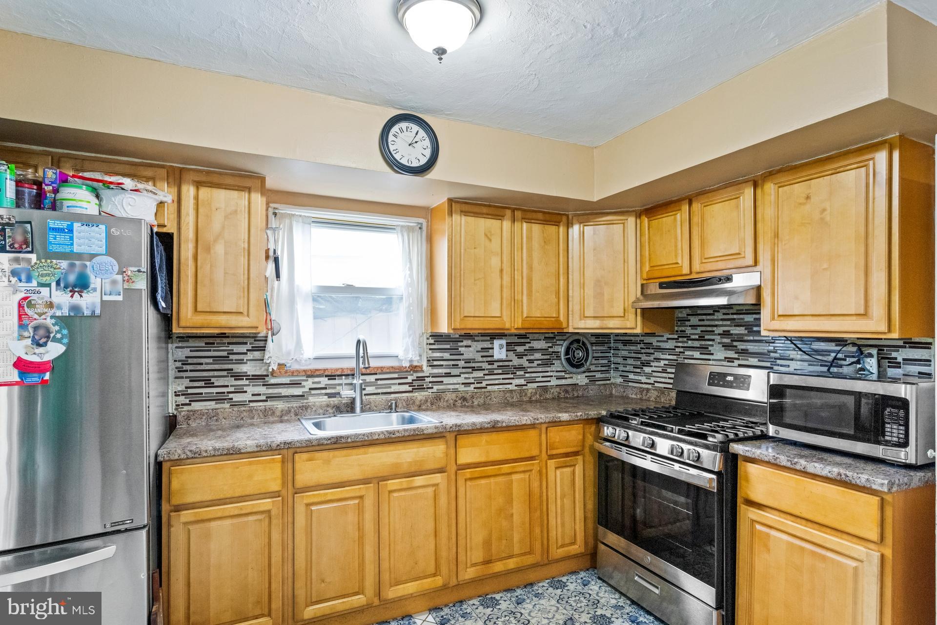 1043 Foster Street Philadelphia, PA 19116 - Photo 12 of 22 a kitchen with stainless steel appliances granite countertop a sink a stove and a refrigerator