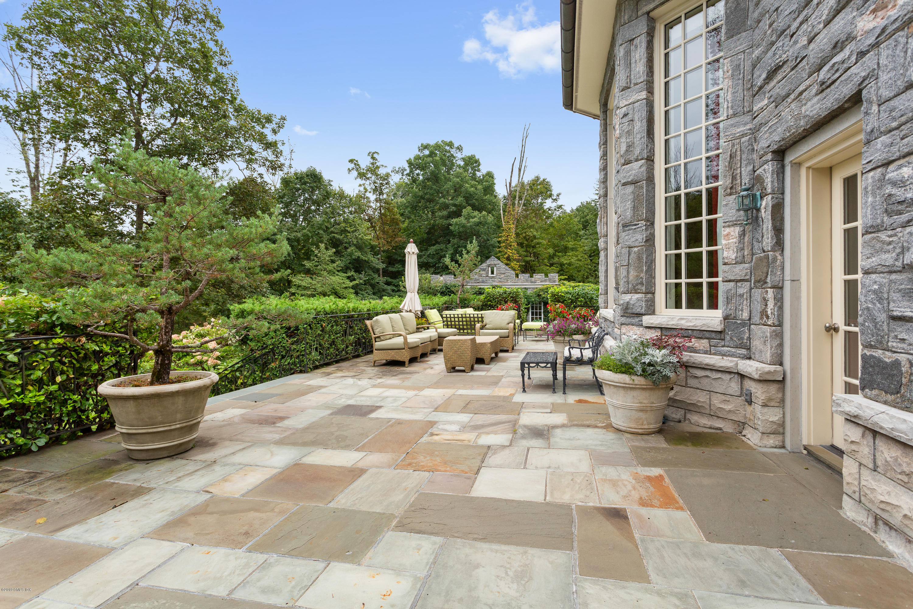 17 Cameron Drive Greenwich, CT 06831 - Photo 28 of 41 a view of a patio with table and chairs and potted plants