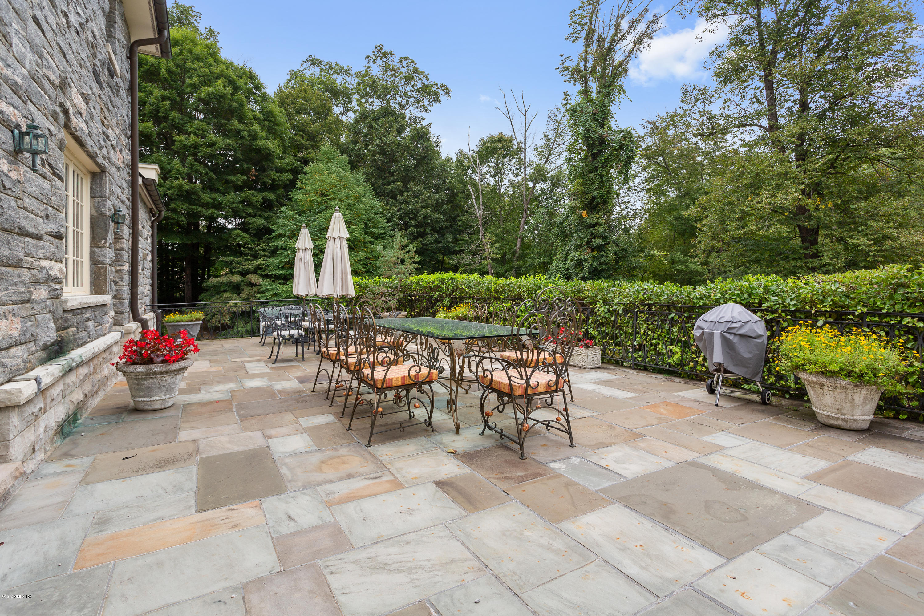 17 Cameron Drive Greenwich, CT 06831 - Photo 29 of 41 a view of a patio with a table and chairs and a fire pit
