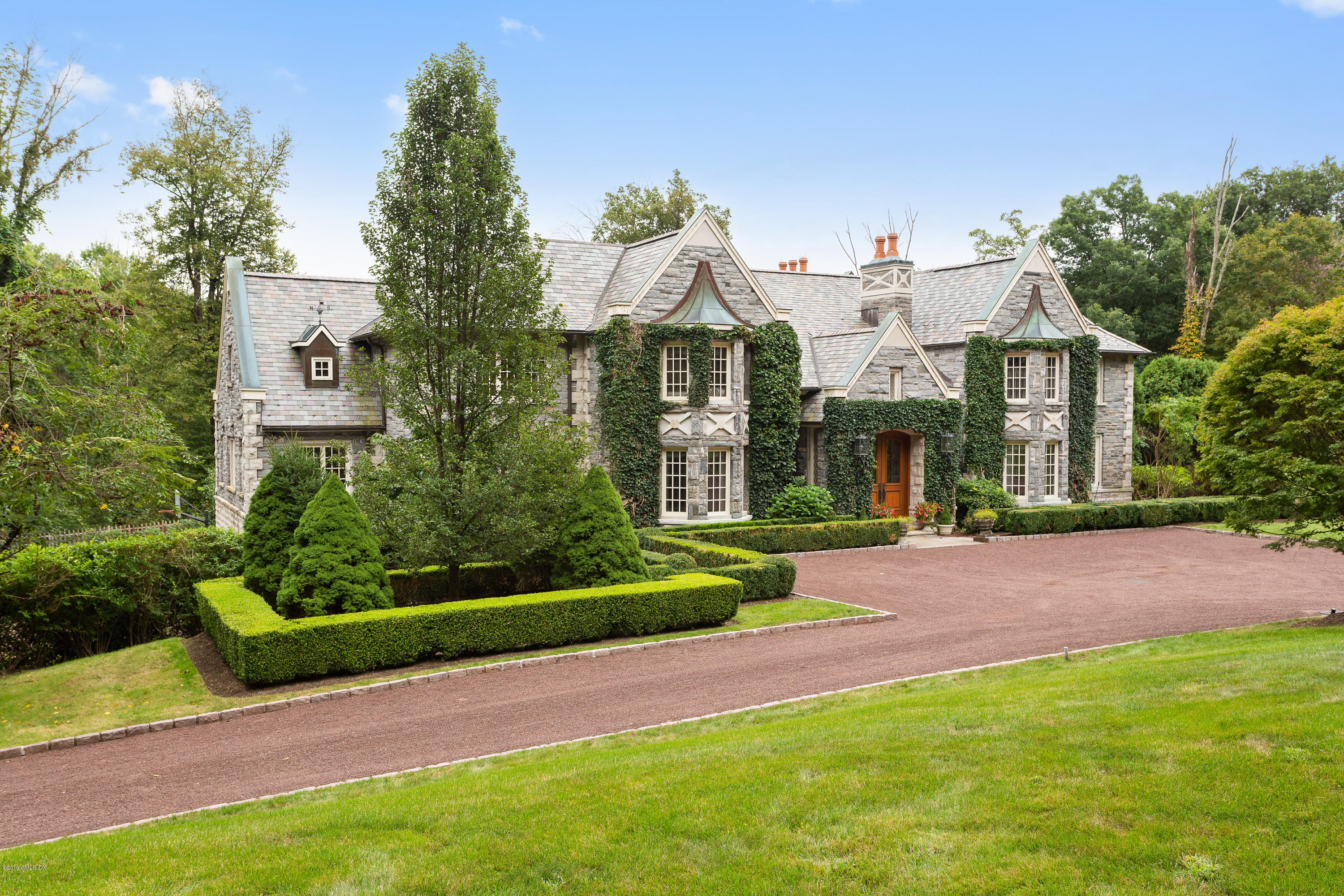 17 Cameron Drive Greenwich, CT 06831 - Photo 3 of 41 a front view of a house with a yard and potted plants