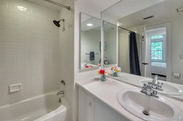 a bathroom with a sink tub vanity and a mirror