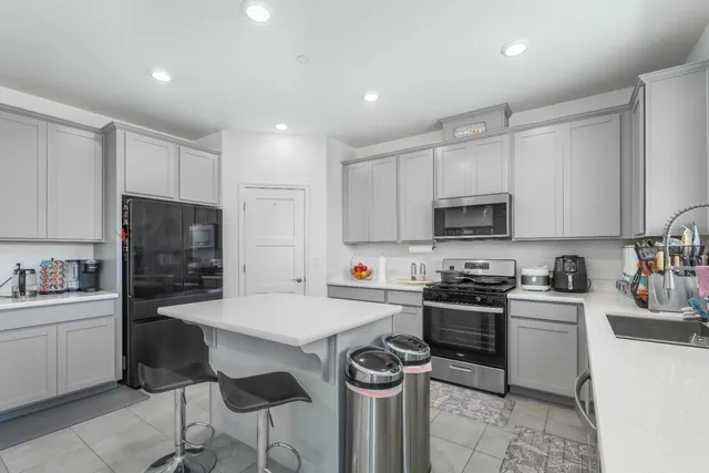 a kitchen with granite countertop a sink stove and refrigerator