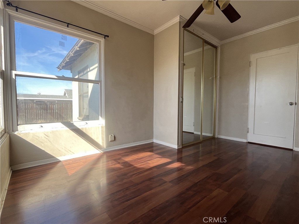 1026 5th Street Calimesa, CA 92320 - Photo 12 of 19 a view of an empty room with wooden floor and a window