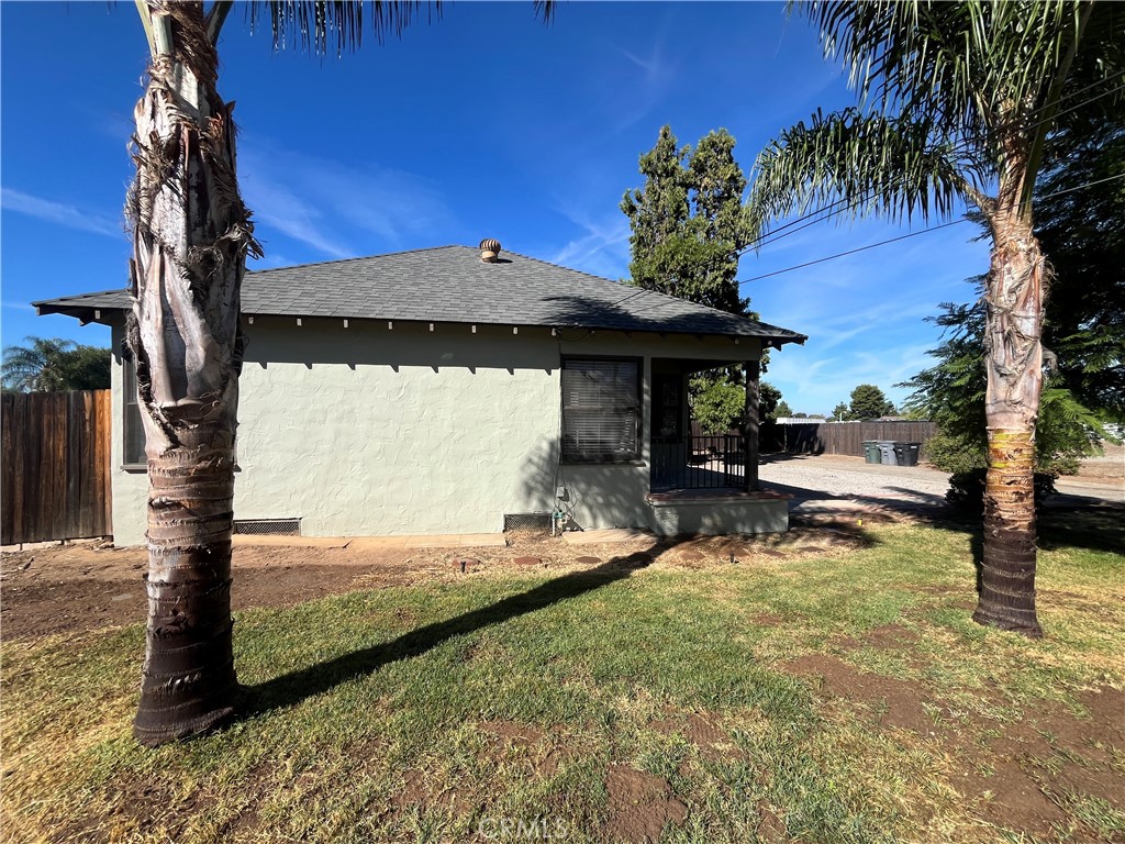 1026 5th Street Calimesa, CA 92320 - Photo 3 of 19 a backyard of a house with table and chairs under an umbrella