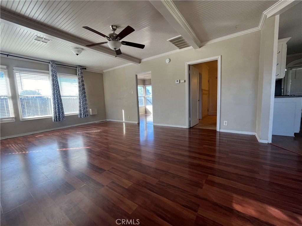 1026 5th Street Calimesa, CA 92320 - Photo 8 of 19 a view of an empty room with wooden floor and a ceiling fan