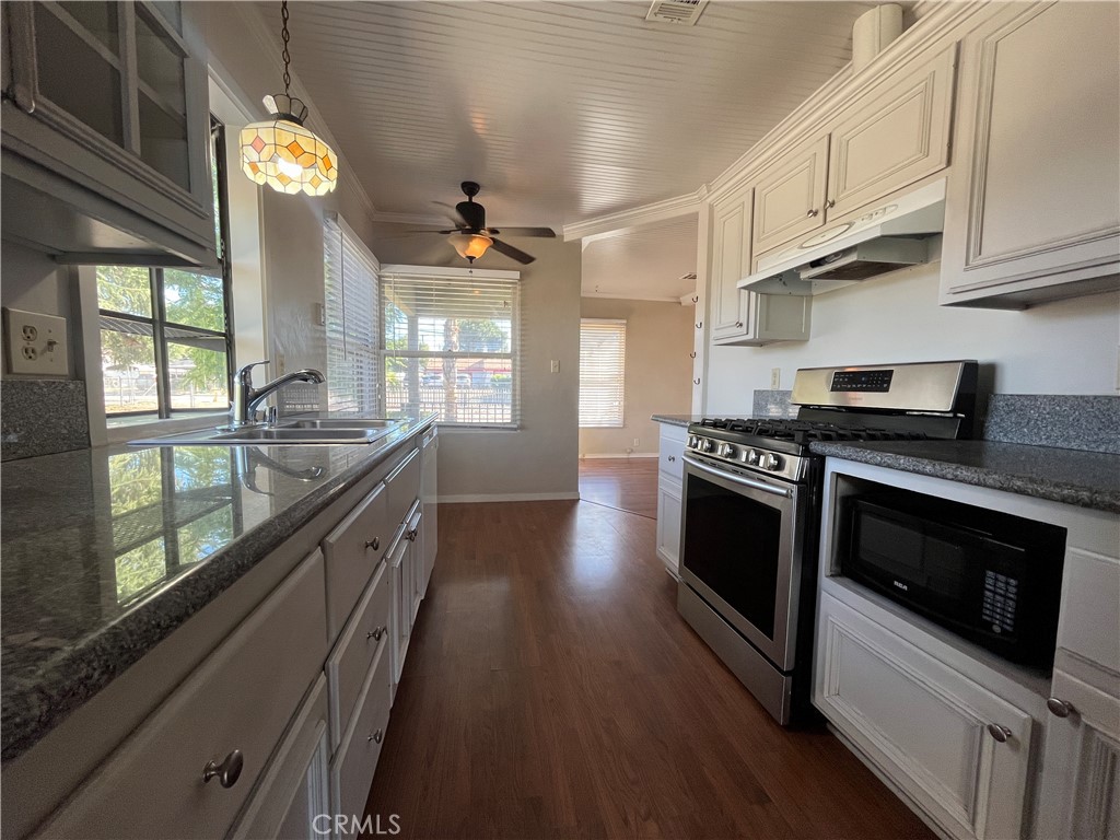 1026 5th Street Calimesa, CA 92320 - Photo 9 of 19 a kitchen with stainless steel appliances granite countertop a stove a sink and a wooden floors