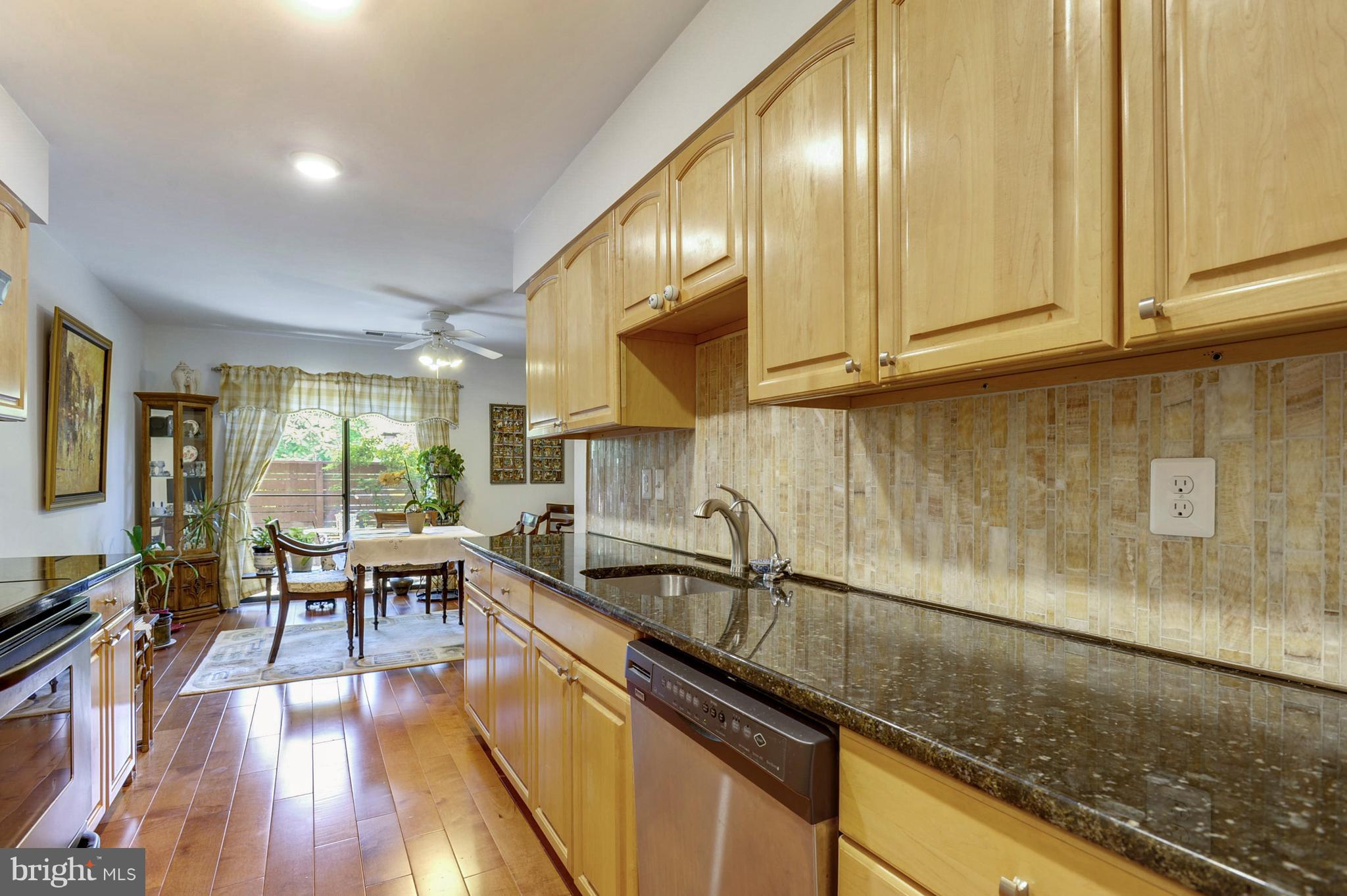 11796 Indian Ridge Road Reston, VA 20191 - Photo 4 of 30 a kitchen with granite countertop a sink stainless steel appliances wooden floor and cabinets