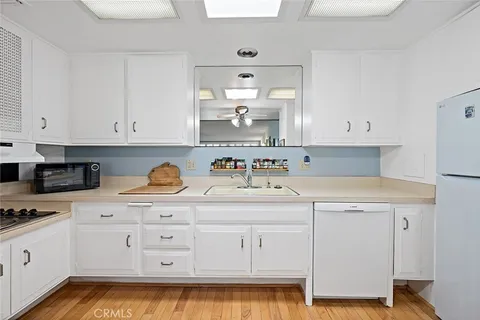 a kitchen with granite countertop white cabinets and white appliances