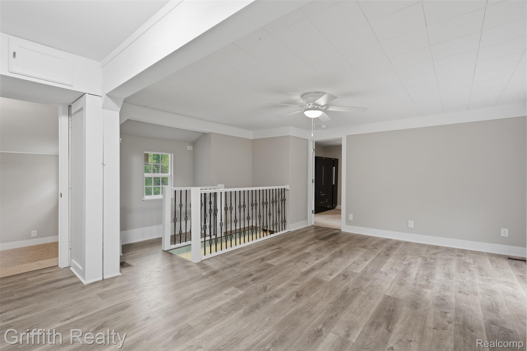 5820 Mack Road Howell, MI 48855 - Photo 7 of 60 Wood-finish flooring throughout, ceiling fan with integrated lighting, white trim and baseboards, and a window with a natural light source