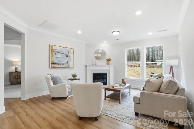 a living room with furniture large window and fireplace