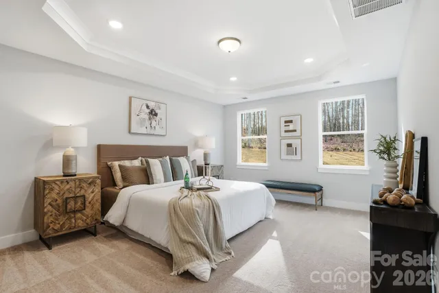 a spacious bedroom with a bed and a lamp