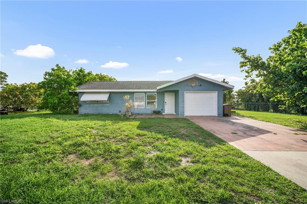 115 Georgia Road Lehigh Acres, FL 33936 - Photo 1 of 26 Ranch-style house with a garage, driveway, and stucco siding