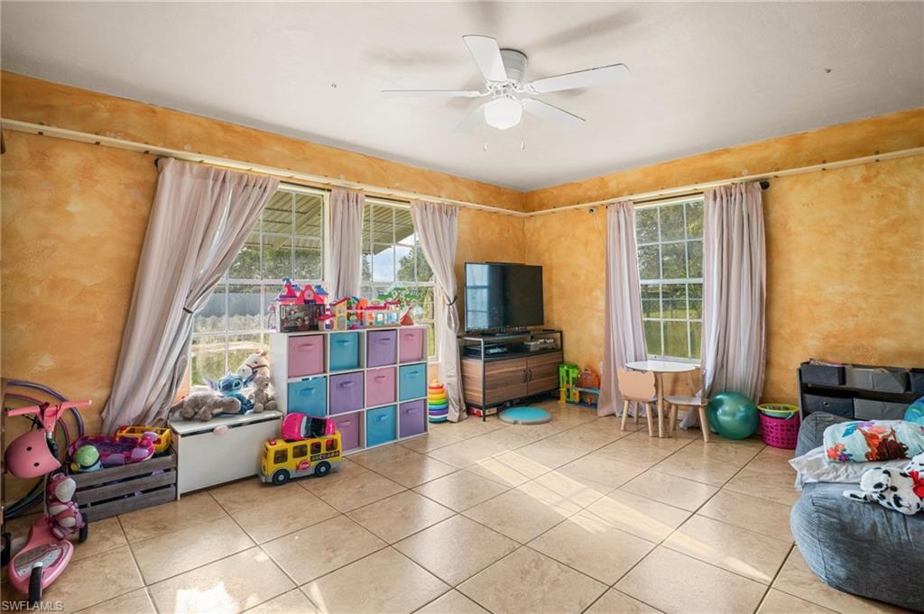 115 Georgia Road Lehigh Acres, FL 33936 - Photo 11 of 26 Game room with plenty of natural light, tile patterned floors, and ceiling fan