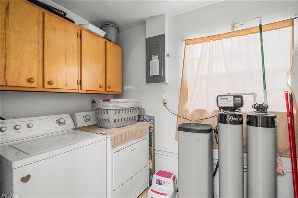 115 Georgia Road Lehigh Acres, FL 33936 - Photo 13 of 26 Laundry area featuring independent washer and dryer, cabinet space, and electric panel