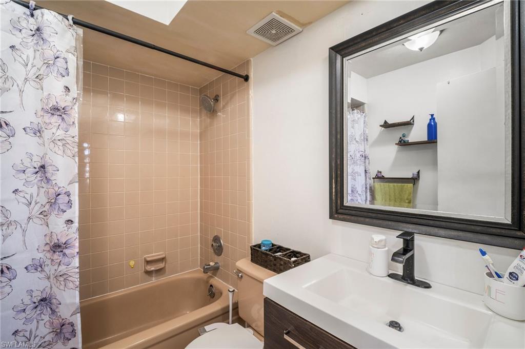 115 Georgia Road Lehigh Acres, FL 33936 - Photo 16 of 26 Bathroom featuring shower / tub combo with curtain, vanity, and toilet