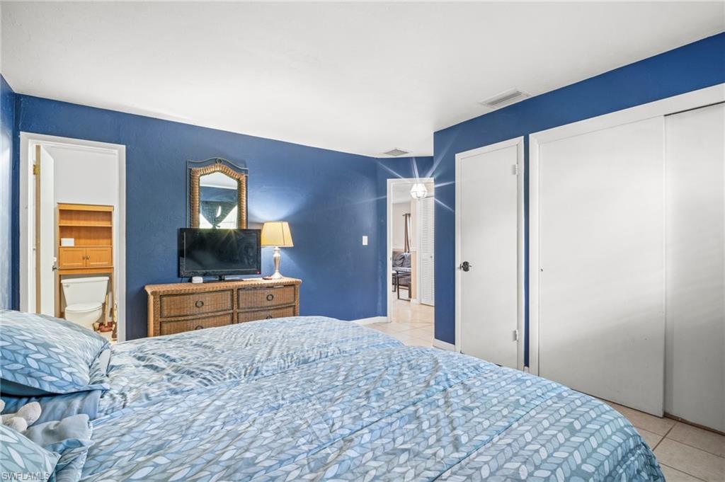 115 Georgia Road Lehigh Acres, FL 33936 - Photo 21 of 26 Bedroom with light tile patterned floors and ensuite bathroom