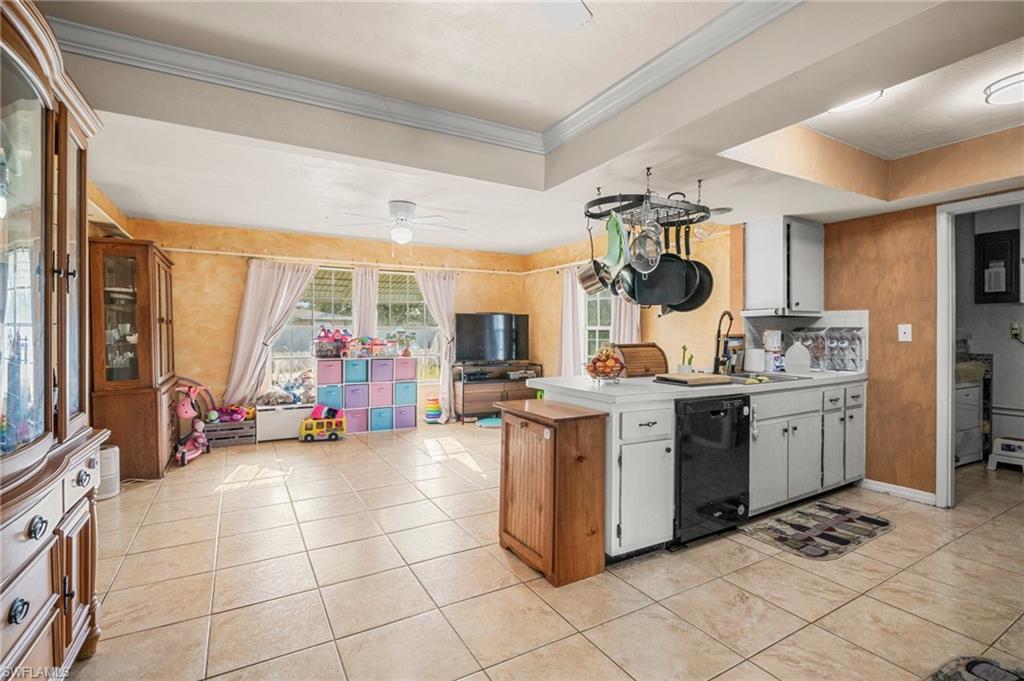 115 Georgia Road Lehigh Acres, FL 33936 - Photo 6 of 26 Kitchen featuring black dishwasher, a sink, a peninsula, light countertops, and light tile patterned floors