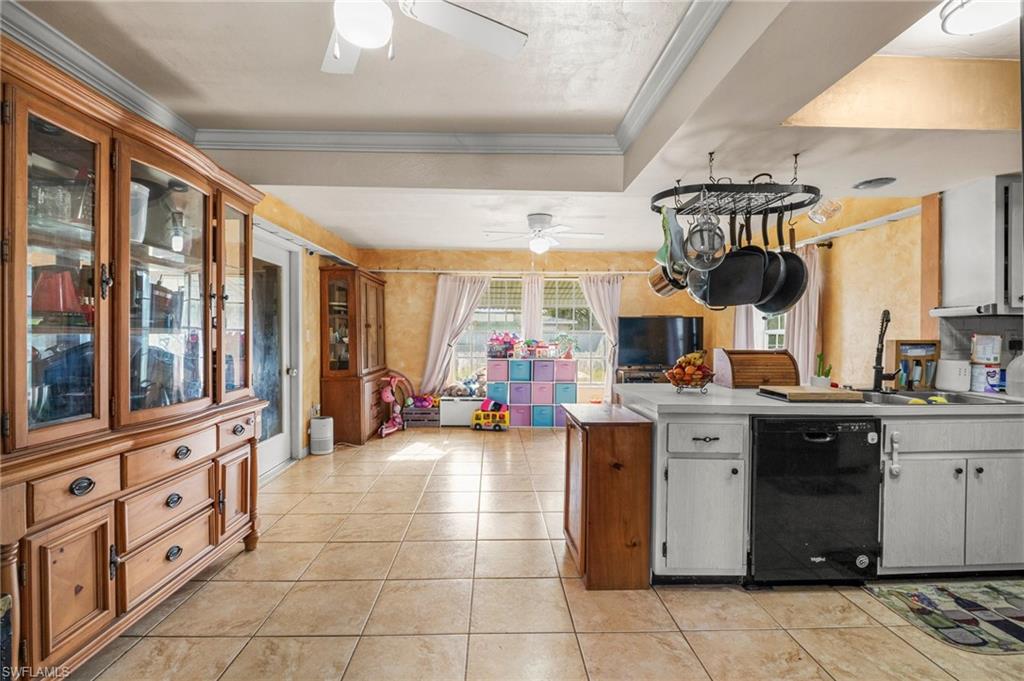115 Georgia Road Lehigh Acres, FL 33936 - Photo 7 of 26 Kitchen with dishwasher, ceiling fan, a peninsula, ornamental molding, and a tray ceiling