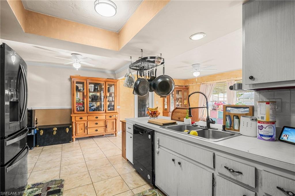 115 Georgia Road Lehigh Acres, FL 33936 - Photo 9 of 26 Kitchen featuring a ceiling fan, black appliances, a sink, light countertops, and light tile patterned floors