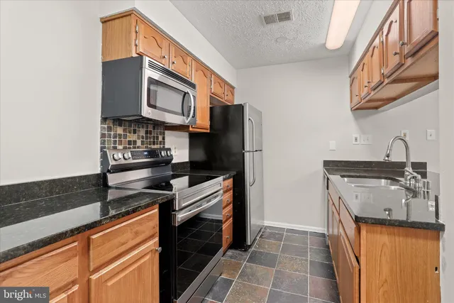 a kitchen with stainless steel appliances a sink stove and refrigerator