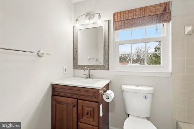 a bathroom with a toilet a sink a vanity and mirror