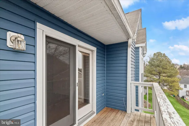 a view of a balcony with wooden floor and fence and a floor to ceiling window