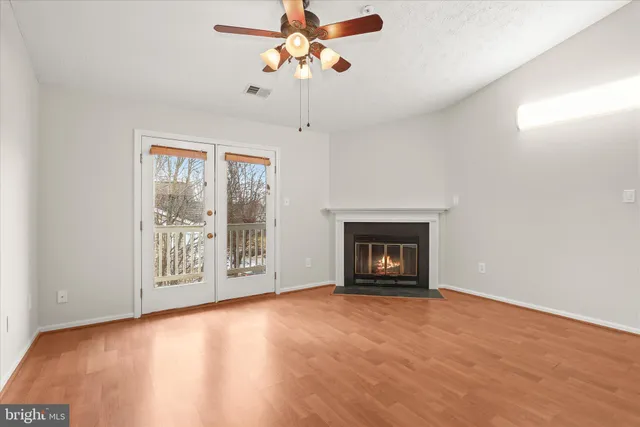 a view of an empty room with a window and a fireplace