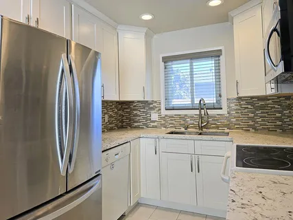 a kitchen with stainless steel appliances a refrigerator sink and cabinets