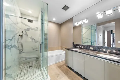 a bathroom with a granite countertop sink a toilet a mirror and shower