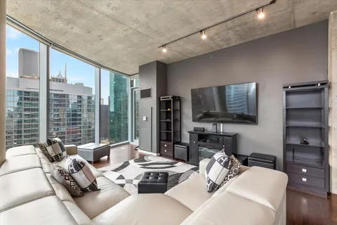 a living room with furniture a large window and a flat screen tv