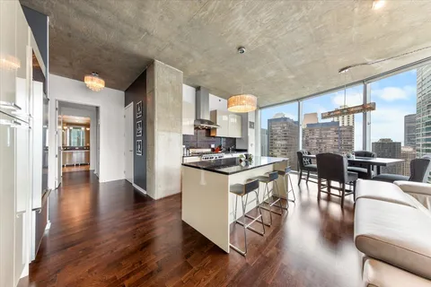a kitchen with stainless steel appliances granite countertop a stove top oven a dining table and chairs with wooden floor