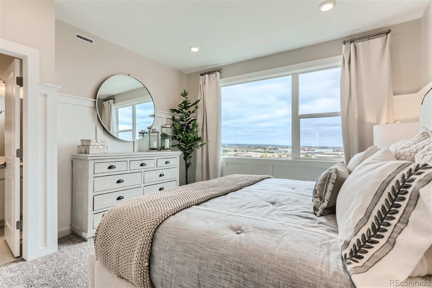 471 Interlocken Boulevard, Unit 101 Broomfield, CO 80021 - Photo 19 of 28 a bedroom with a bed a table and a large mirror