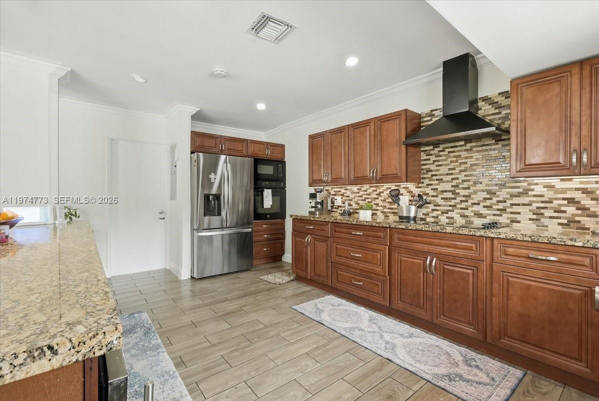 4925 Tyler Street Hollywood, FL 33021 - Photo 12 of 55 a kitchen with stainless steel appliances granite countertop a sink stove and refrigerator