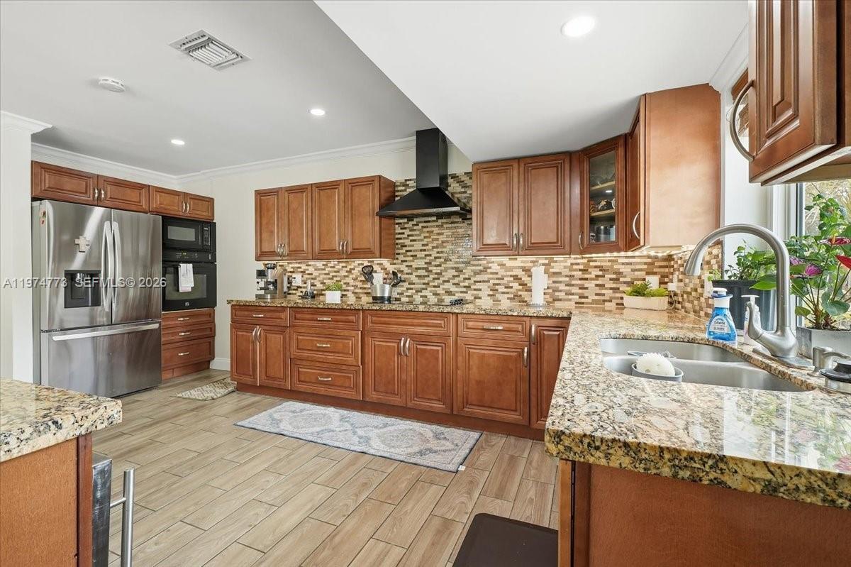 4925 Tyler Street Hollywood, FL 33021 - Photo 14 of 55 a kitchen with stainless steel appliances granite countertop a sink stove and refrigerator