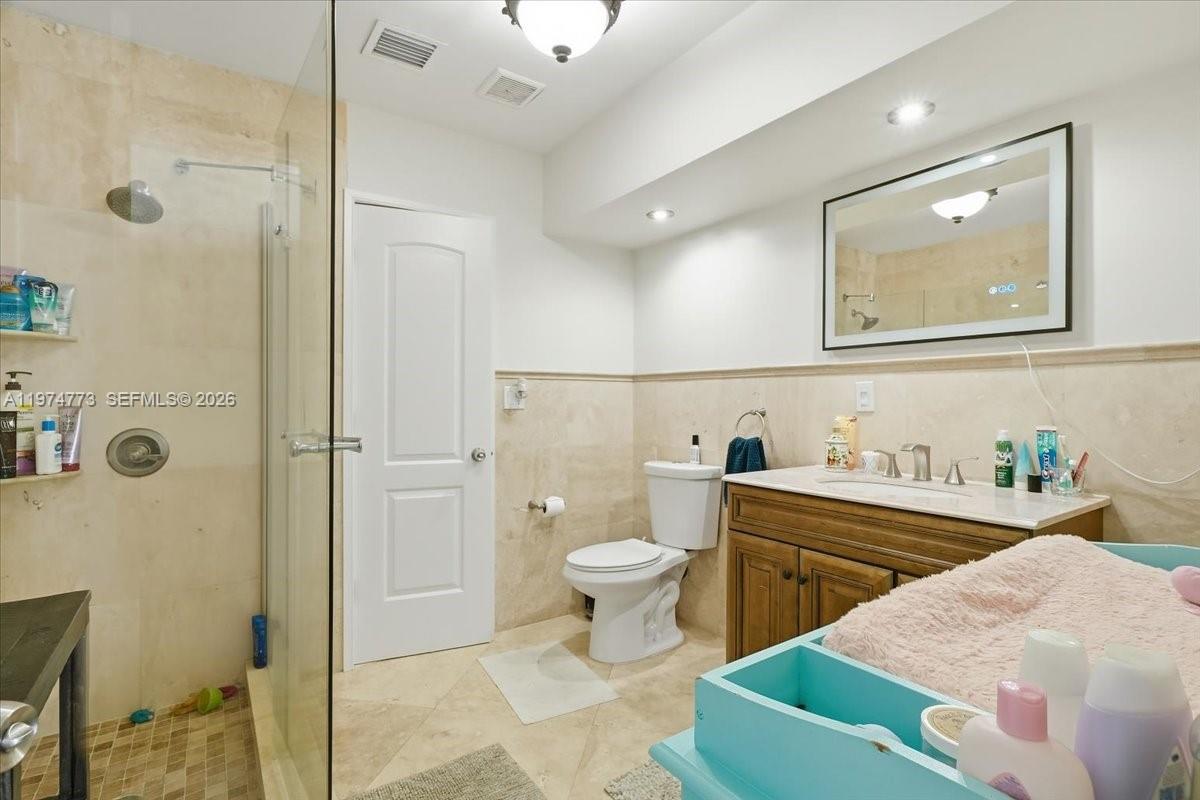 4925 Tyler Street Hollywood, FL 33021 - Photo 33 of 55 a spacious bathroom with a toilet sink and mirror