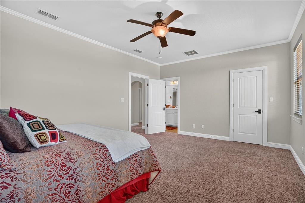 100 Canyon Ridge Trail Aledo, TX 76008 - Photo 16 of 38 Spacious primary bedroom suite with ceiling fan, ensuite bathroom access, neutral wall finishes, and carpet flooring