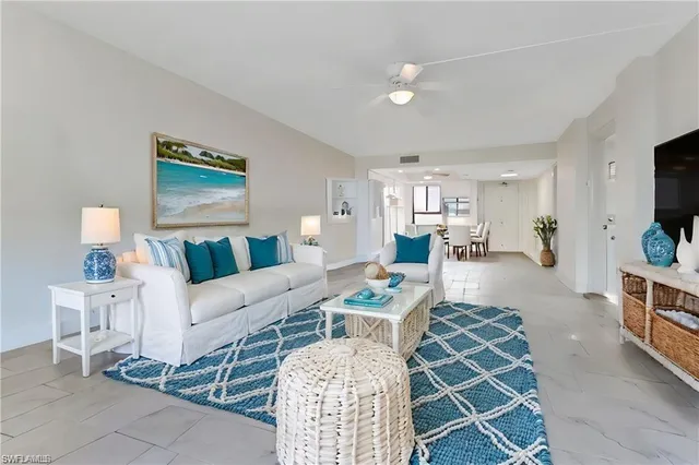 a living room with furniture a flat screen tv and a table