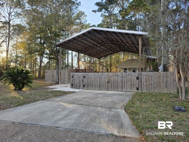 182 Defuniak Loop Lillian, AL 36549 - Photo 1 of 21 View of parking with a detached carport and a gate