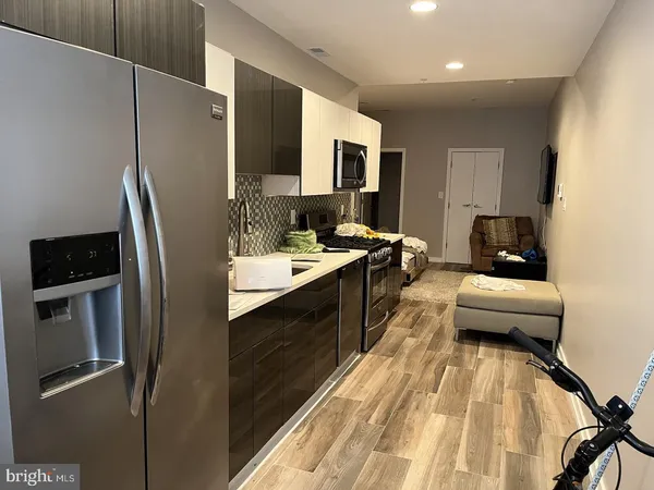 a kitchen with stainless steel appliances granite countertop a refrigerator a stove and a sink
