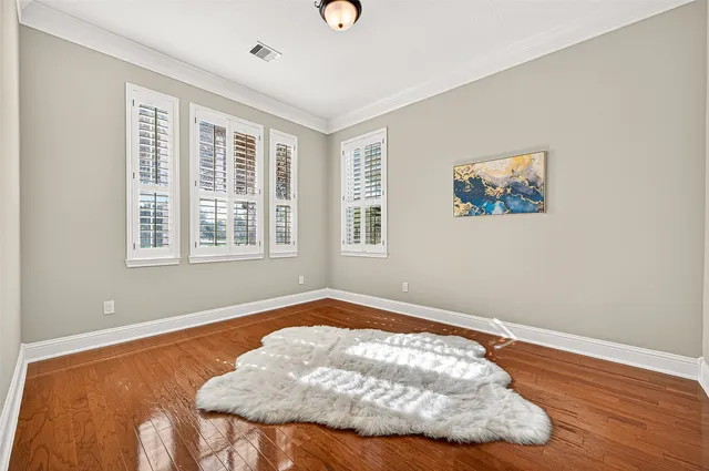 a view of a bedroom with wooden floor and window