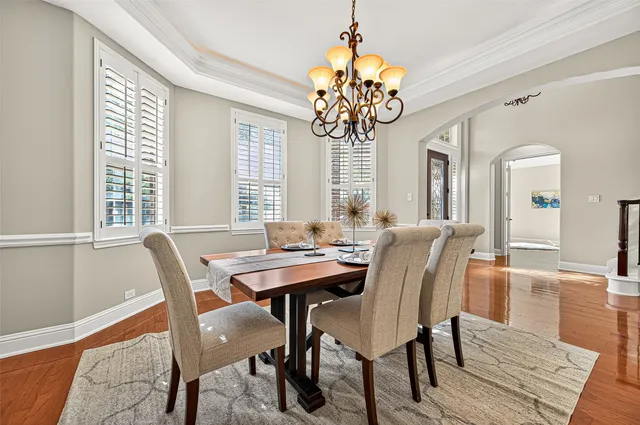 a view of a dining room with furniture a chandelier and wooden floor